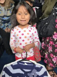 cute-little-girl-in-trailer-holding-clothing-225x300